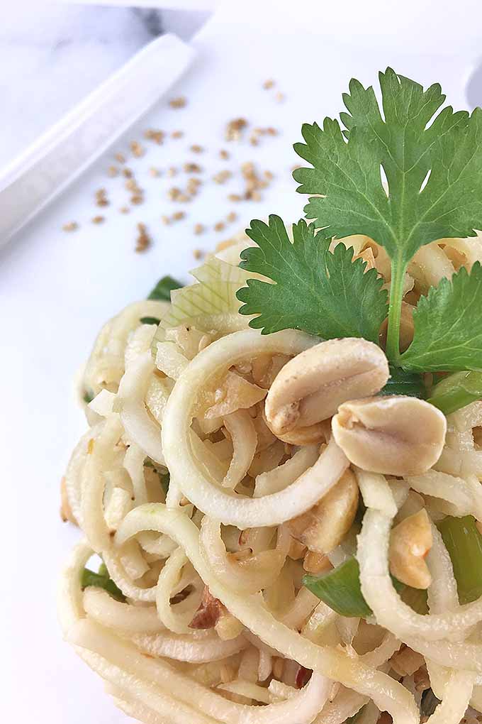 Spiralized kohlrabi slaw with crushed peanuts and a cilantro garnish.