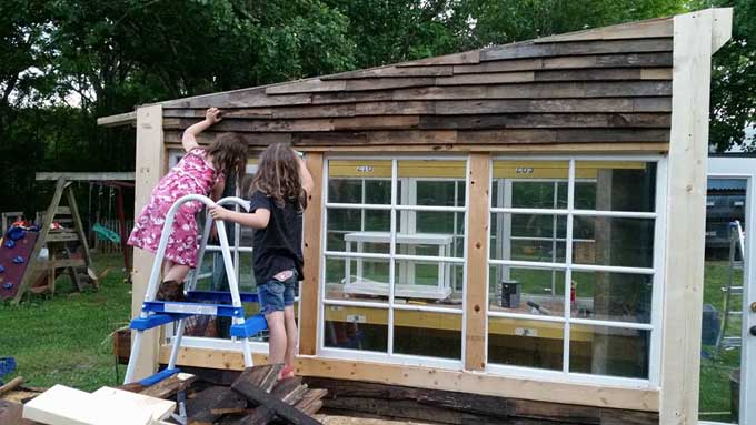 Little girls helping to build the pallet rack greenhouse | Gardener's Path