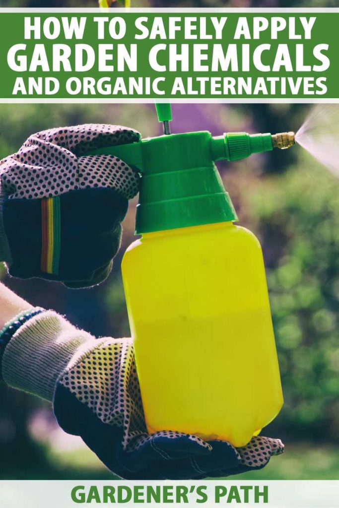 A pair of gloved human hands operates a sprayer to apply chemicals in a garden.