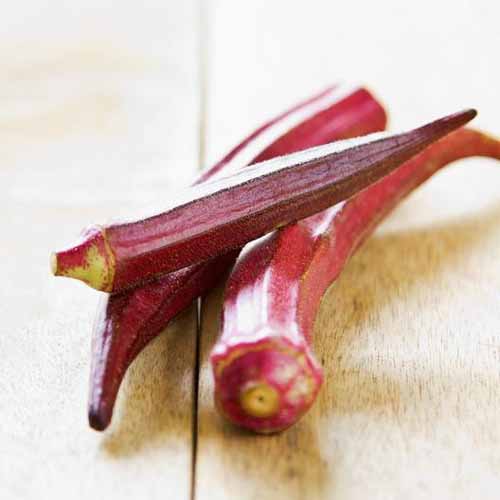 Red Burgandy Okra Seeds on a white, isolated background.