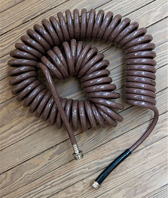 Top down view of the Gatorhyde Coiled Garden Hose on a wooden deck.