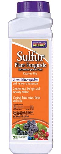 A close up vertical picture of the packaging of a fungicidal spray that is sulfur based with orange and purple livery, on a white background.