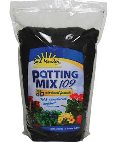A close up vertical image of the packaging of Soil Mender's potting mix pictured on a white background.