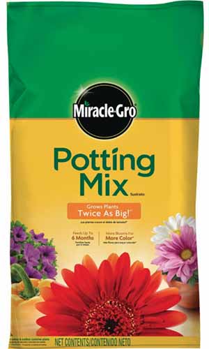 A close up vertical image of the packaging of MiracleGro Potting Mix pictured on a white background.