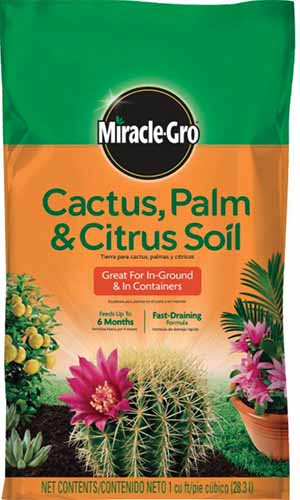 A close up vertical image of the packaging for MiracleGro potting soil pictured on a white background.