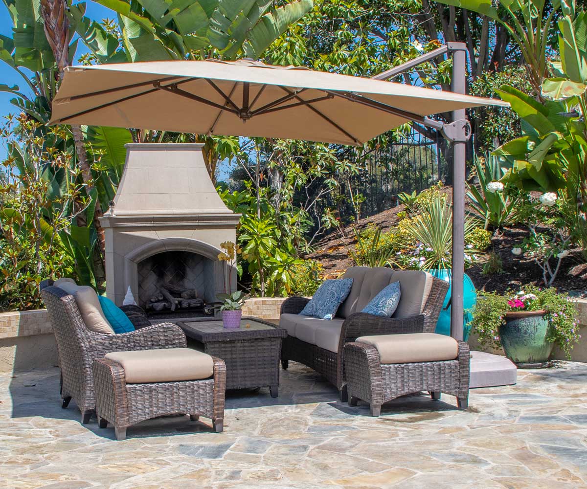 An outdoor fire place with an outdoor furniture set along with a cantilever or offset patio umbrella. 