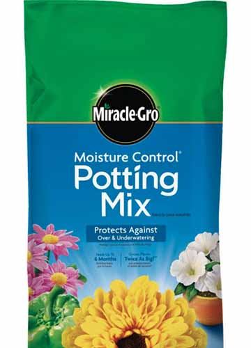 A close up vertical image of the packaging of Miracle-Gro Potting Mix on a white background.