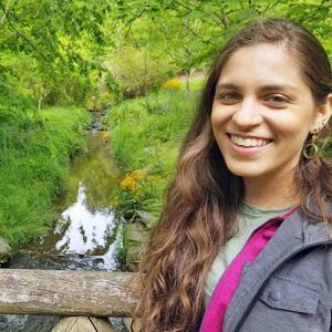 Allison Sidhu profile image, with stream and trees in background.
