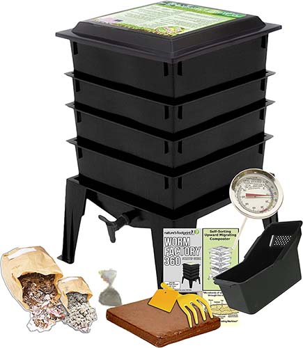 A close up vertical image of the contents of the Worm Factory 360 Black Worm Composting Kit isolated on a white background.