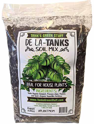 A close up vertical image of a bag of Tank's Green Stuff De La Tanks Soil Mix isolated on a white background.