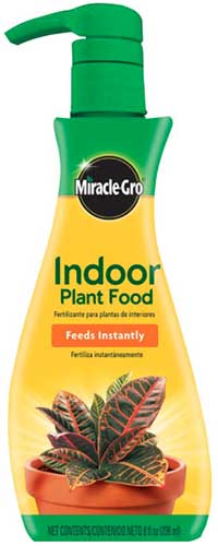 A close up vertical image of a bottle of Miracle-Gro Indoor Plant Food isolated on a white background.