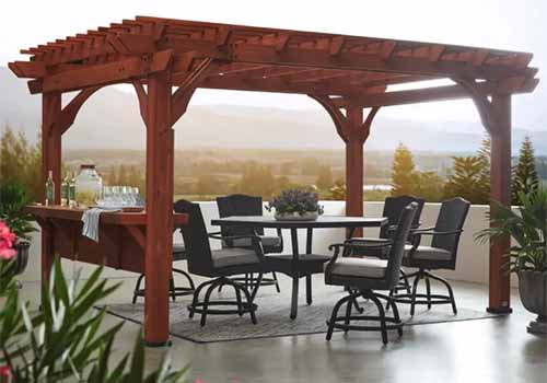 A close up horizontal image of a large wooden pergola over an outdoor seating area.