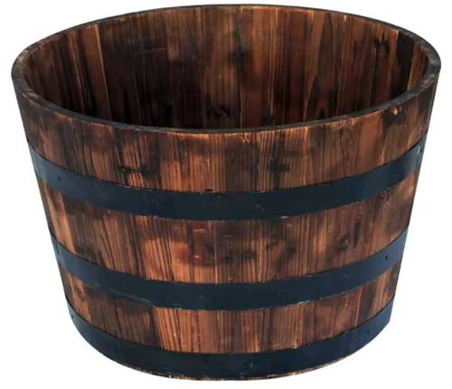A close up square image of a wooden whiskey barrel planter isolated on a white background.