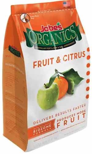 A close up of the packaging of Jobe's Fruit and Citrus Fertilizer isolated on a white background.