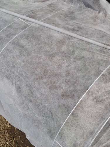 A close up of lightweight row cover fabric for protecting vegetables from pests.