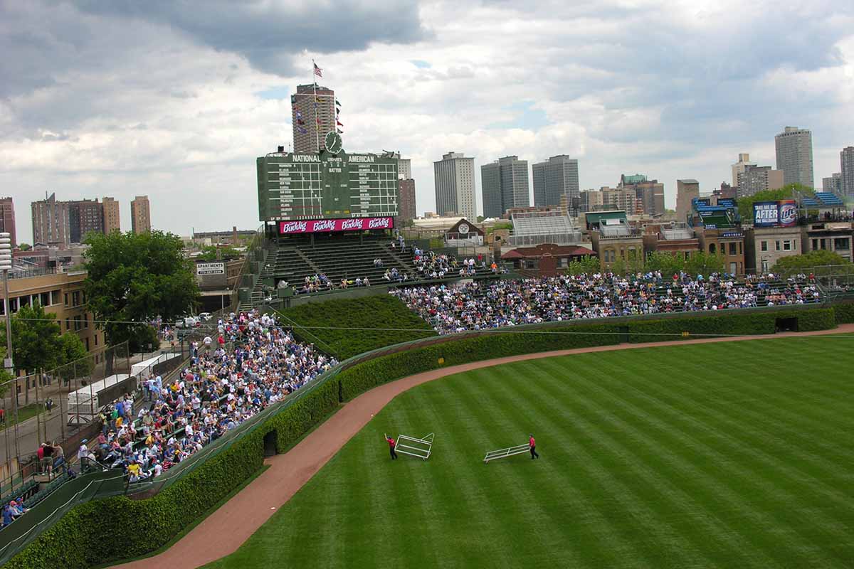 A horizontal elevated view of Wrigley field with audience members in the bleachers.
