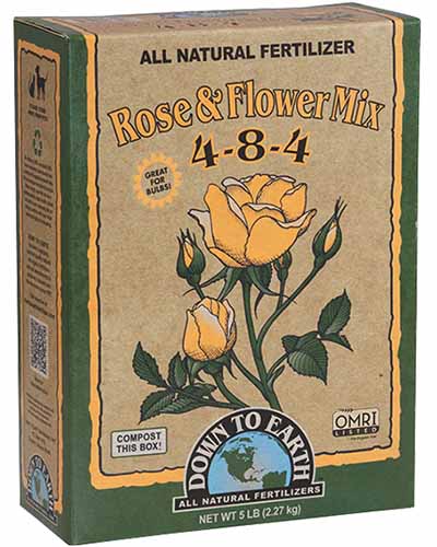 A close up of a box of Down to Earth Rose and Flower Mix All Natural Fertilizer pictured on a white background.
