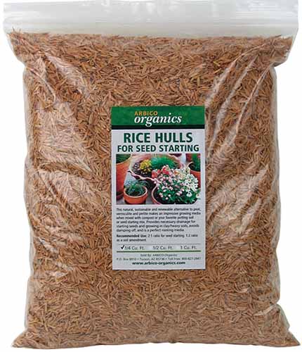 Um close-up de um saco de cascas de arroz para sementes começando isoladas em um fundo branco.
