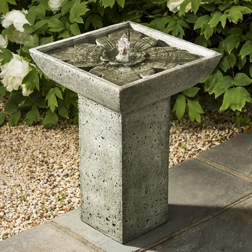 A close up of a Campania International Concrete Andra Fountain set outdoors in the garden.