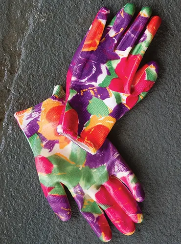 A close up of brightly colored Floral Infusion gloves set on a gray surface.