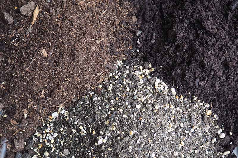 A close up horizontal image of the ingredients of a homemade soil blend.