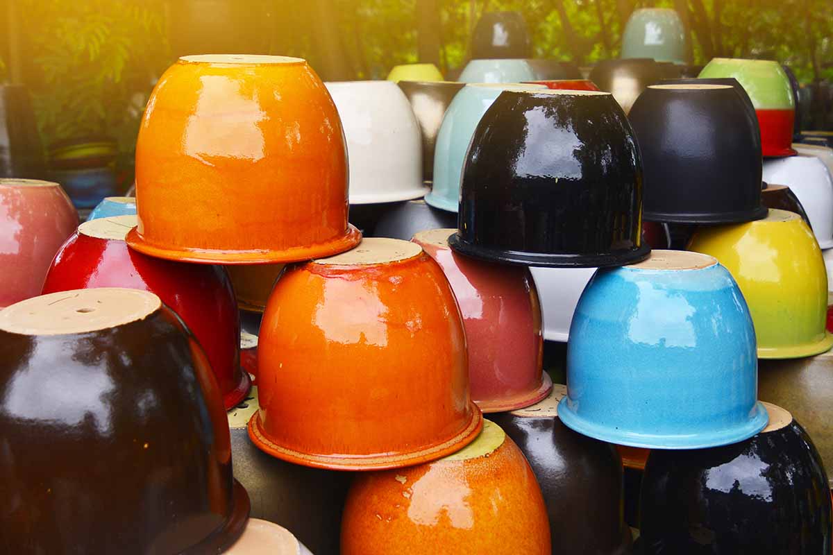 A close up horizontal image of different types of plant pots stacked upside down for sale at a garden center.