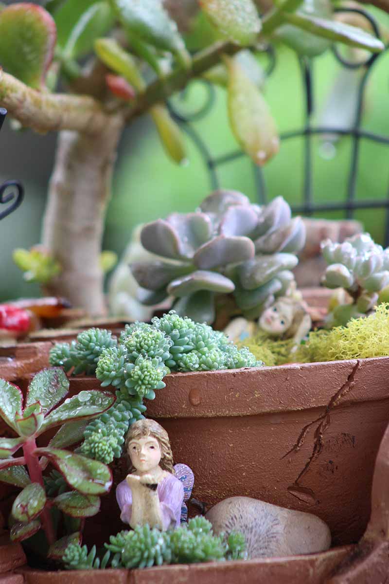 A close up vertical image of a multi-tired pot used for a heavenly themed fairy garden.