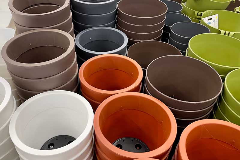 A close up horizontal image of a selection of pots available for sale at a garden center.