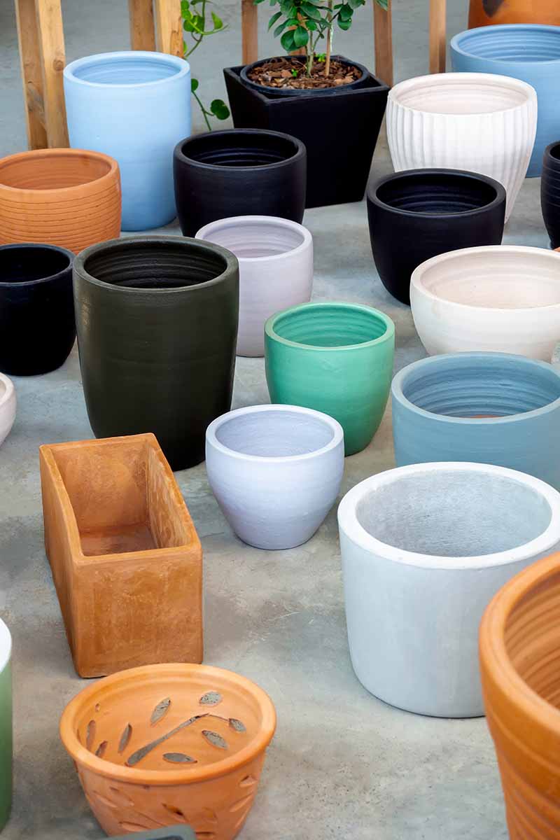A vertical image of a selection of different pots and planters at a garden center.