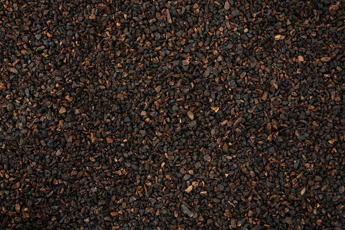 A horizontal close up shot of ground chicory root with a consistency of instant coffee granules.