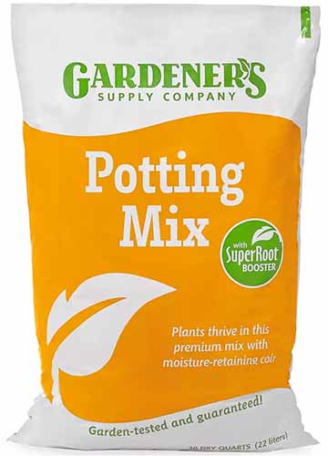 A vertical shot of a potting mix from Gardener's Supply Co. in an orange, white, and green bag, placed in front of a white background.