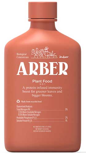 A small vertical shot of a light rust colored bottle of Arber plant food against a white background.