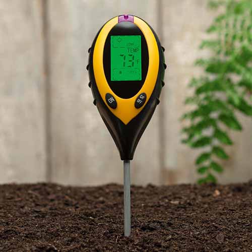 A square product shot of a four-in-one soil tester in soil.