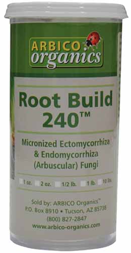 A close up of a bottle of Root Build 240 inoculant isolated on a soft focus background.