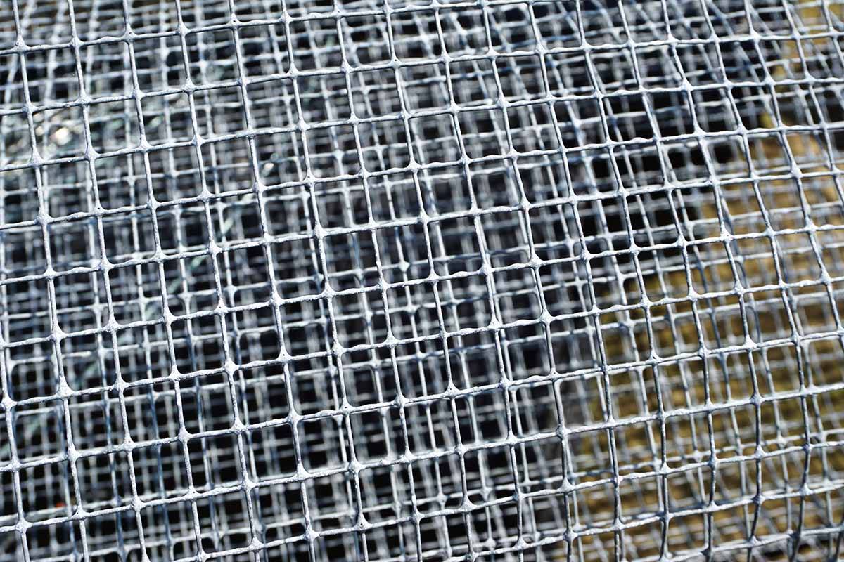 A close up horizontal image of steel galvanized hardware cloth in a roll.