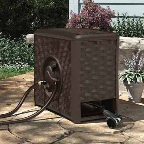 A square image of a brown Suncast automatic hose reel out in the garden.