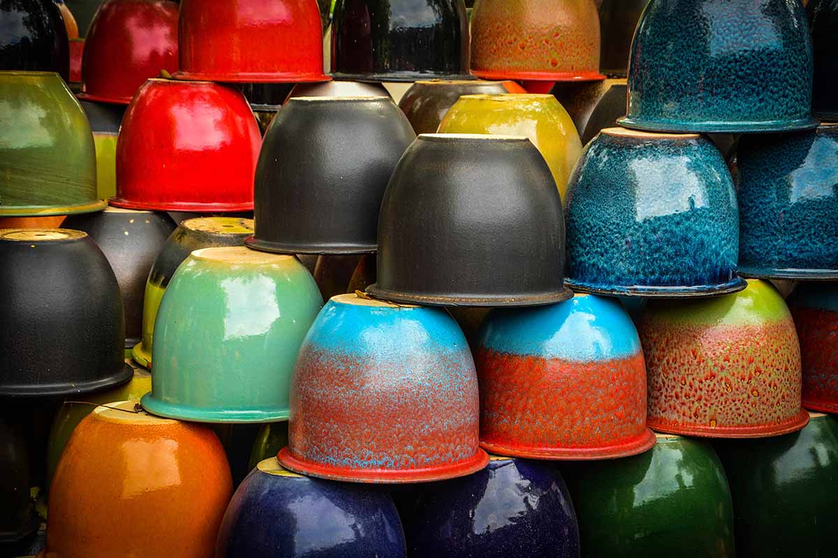 A horizontal image of a stack of colorful ceramic pots at a garden center.