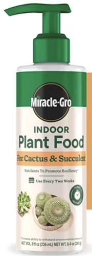 A close up of a bottle of Miracle Gro Indoor Plant Food isolated on a white background.